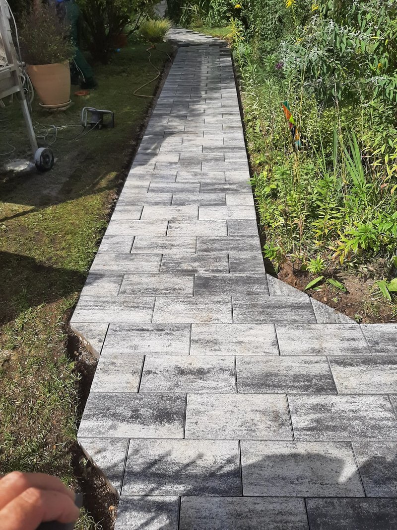 Gepflasterter Gartenweg mit grau gemusterten Steinen